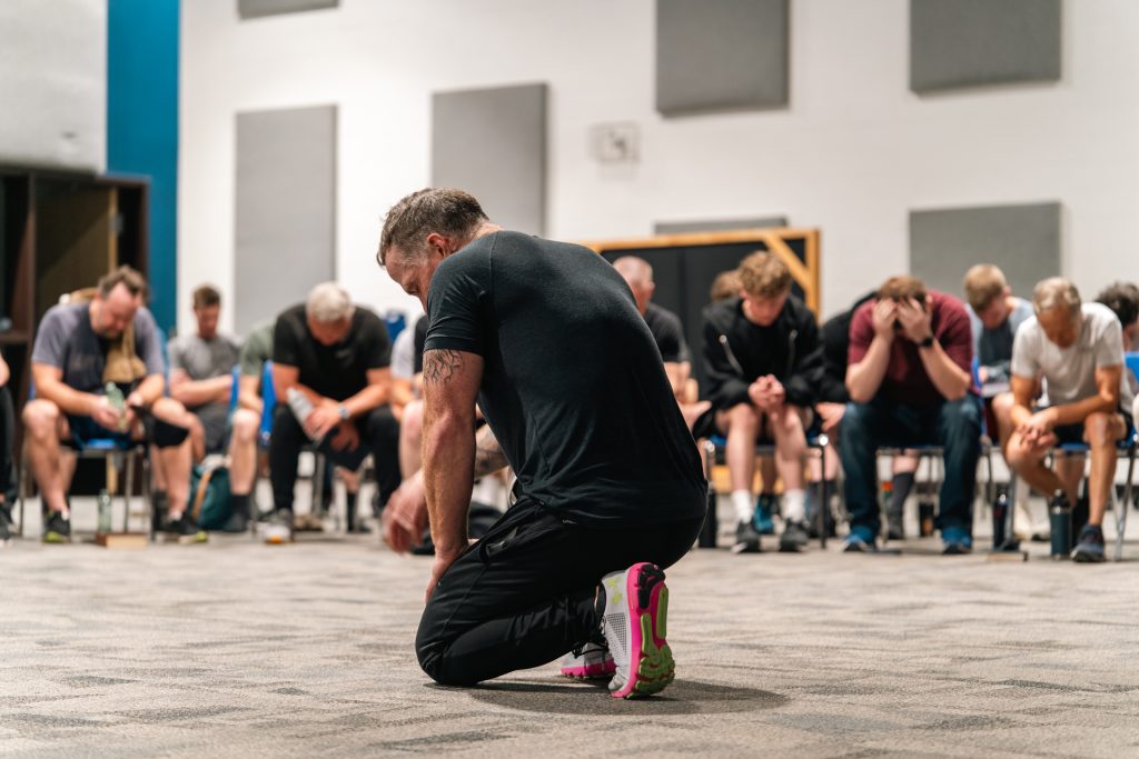 Christian men praying together for strength and faith