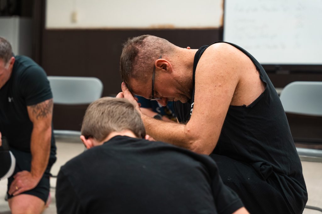 Christian men praying together for strength and faith