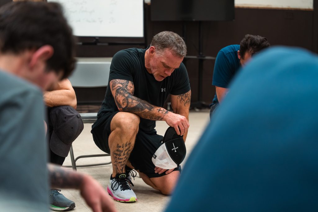Christian men praying together for strength and faith