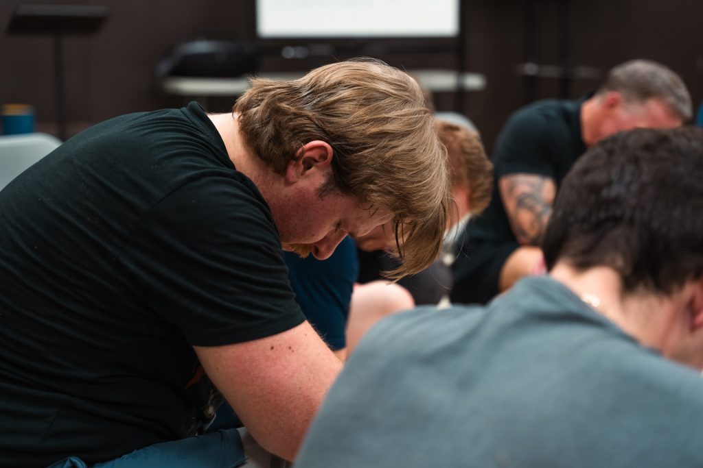 Christian men praying together for strength and faith