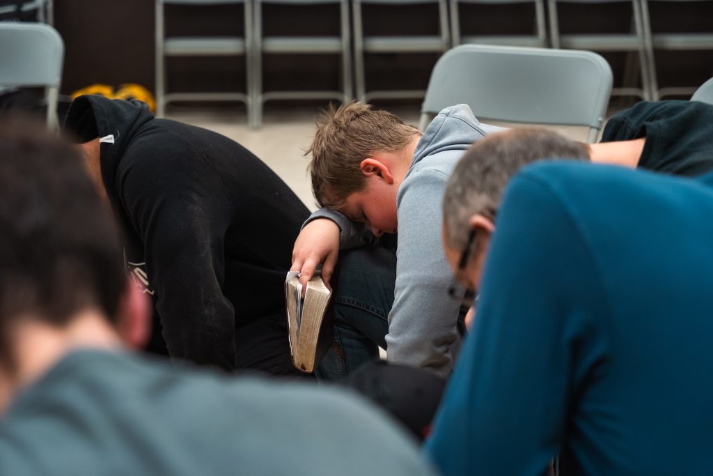 Christian men praying together for strength and faith